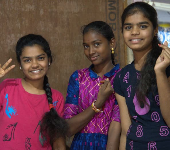 three Indian girls waving